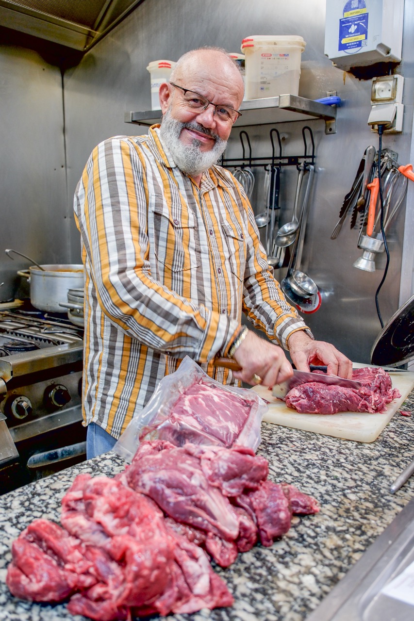 Le chef de Baladna, fort de 38 ans de métier, préparant la viande en cuisine
